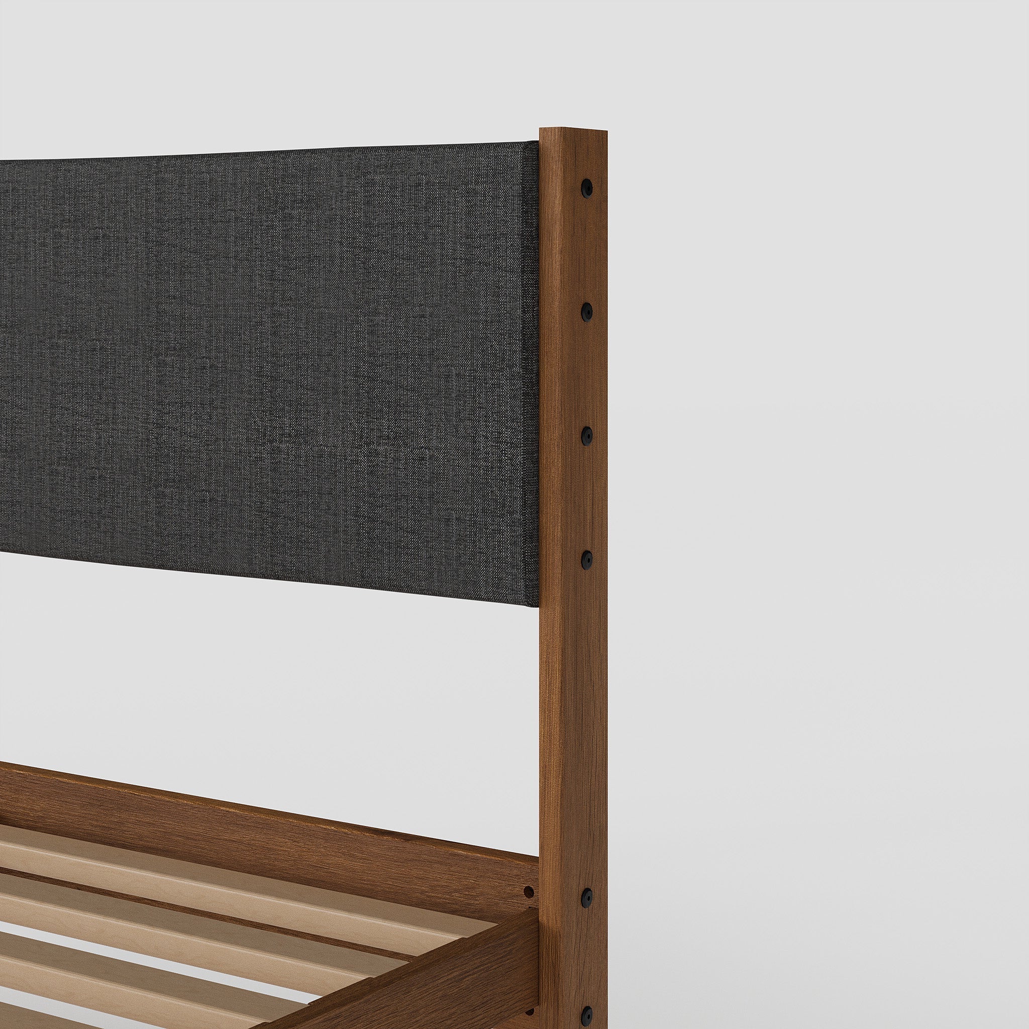Wooden bed frame with a dark fabric headboard on a white background