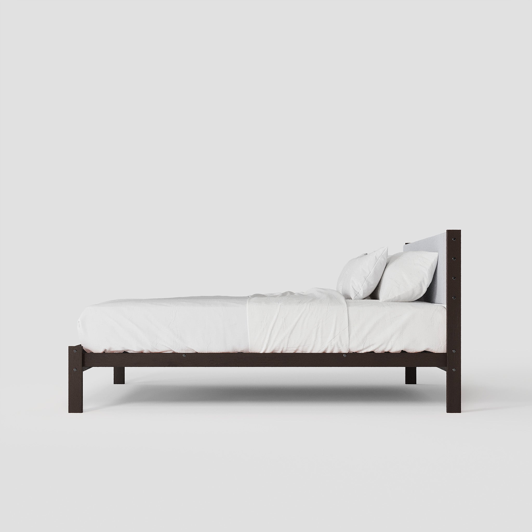 Wooden bed frame with white bedding on a plain background