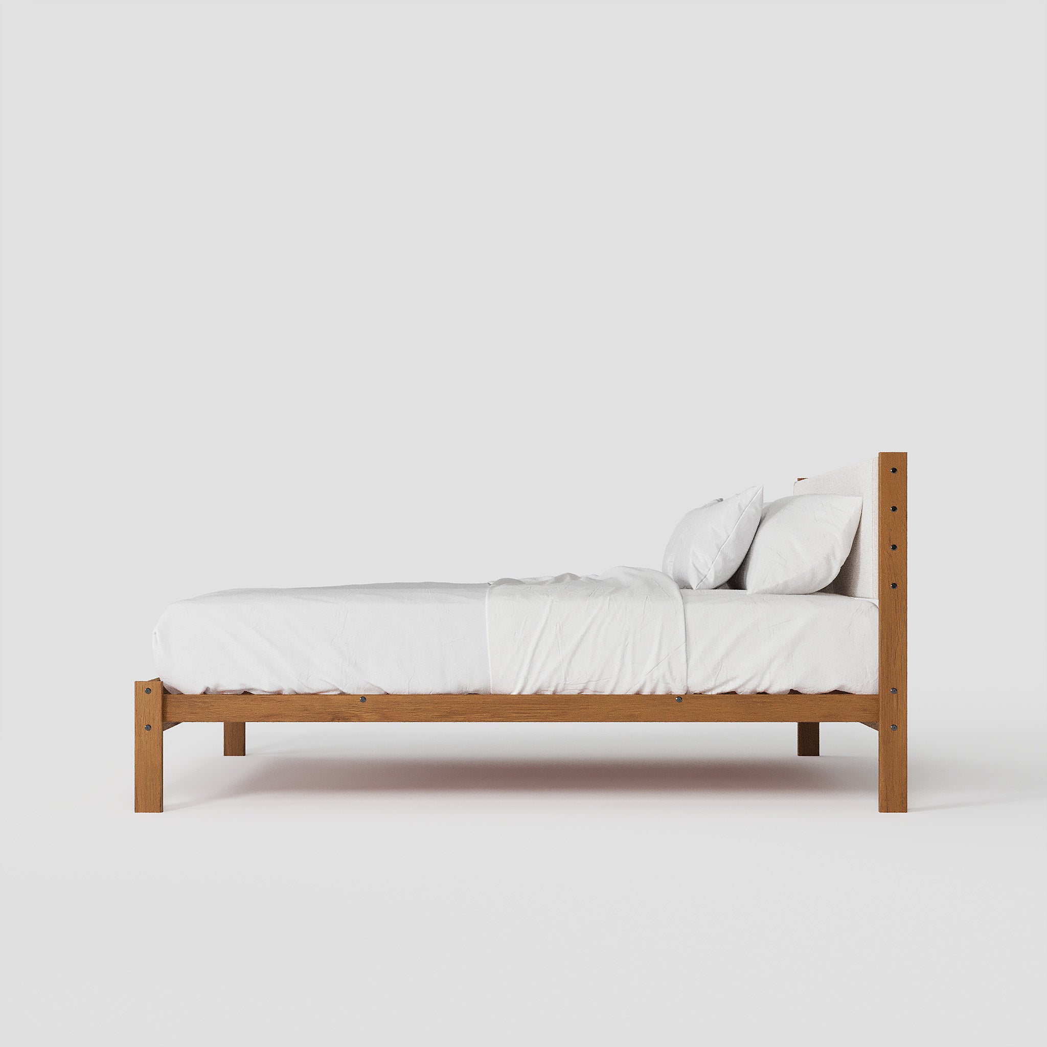Wooden bed frame with white bedding on a plain background